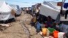 FILE - Displaced families, who fled from Islamic State violence in Mosul, sit at the Ali Awa refugee camp near Khanaqin city, Iraq, Oct. 22, 2014.