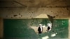 Palestinian students look inside a classroom that witnesses said was shelled by Israel during its offensive, on the first day of the new school year east of Gaza City September 14, 2014.