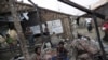 FILE - Rohingya people pass their time in a damaged shelter in a Rohingya displaced-persons camp outside Sittwe, Rakhine state, Myanmar, Aug. 4, 2015
