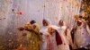 Widows throw flowers into the air during a holi celebration at the Meera Sahavagini ashram in Vrindavan in the northern Indian state of Uttar Pradesh, Mar. 24, 2013.