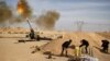 FILE - Libya Dawn fighters fire an artillery cannon at Islamic State militants near Sirte, March 19, 2015.