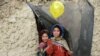 Internally displaced Afghan children play outside their temporary home at a refugee camp in Kabul, Afghanistan.
