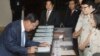 Cambodia's Prime Minister Hun Sen, left, registers before a meeting at National Assembly, in Phnom Penh, Cambodia, Monday, Feb. 20, 2017. Cambodia's legislature has approved amending a law governing political parties that would allow the government to app