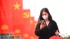 FILE - A woman wearing a face mask looks at her phone in Hanoi, Vietnam, Jan. 23, 2021. Vietnam says it has discovered a new coronavirus variant that’s a hybrid of strains first found in India and the U.K. (Reuters)