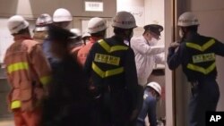 Emergency workers and police investigate the scene at a train station in Tokyo on Oct. 31, 2021, after a man brandishing a knife on a commuter train stabbed several passengers before starting a fire.