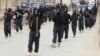 FILE - Fighters of al-Qaida linked Islamic State of Iraq and the Levant carry their weapons during a parade at the Syrian town of Tel Abyad, near the border with Turkey, January 2014.