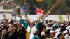 A supporter of Aam Aadmi (Common Man) Party (AAP) cheers after its leader Arvind Kejriwal took an oath as the new chief minister of Delhi during a swearing-in ceremony at Ramlila ground in New Delhi, Dec. 28, 2013. 