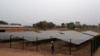 Un ingénieur se tient à côté d'une clôture protégeant un panneau solaire installé dans le village de Takpapieni dans la province d'Oti, au nord du Togo, le 14 février 2020. (Photo AFP/ PIUS UTOMI EKPEI)
