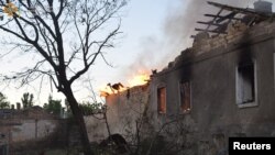 A firefighter works to douse a fire in a building, as Russia's attack on Ukraine continues, in Mykolaiv