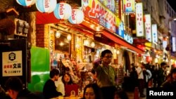 Foto ilustrasi yang menunjukkan sejumlah warga menikmati makanan dan minuman di restoran izakaya distrik Ameyoko, Tokyo, Jepang, pada 15 Februari 2024. (Foto: Reuters/Issei Kato)