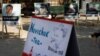 FILE - A poster showing Russian opposition leader Alexei Navalny (L) with the word "poisoned" and a mock offering of "Novichok Tea" are seen outside the Russian embassy in Berlin, Germany, during a protest, Sept. 23, 2020.
