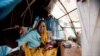 FILE - Aid workers have expressed alarm at poor conditions in South Sudan refugee camps. A woman and baby shelter in a makeshift tent at the Kalma refugee camp.