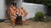 FILE - Members of a burial team, wearing protective suits, remove a body from an Ebola holding center at the Port Loko District Hospital in Sierra Leone, Sept. 27, 2014. 