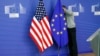 A worker adjusts European Union and U.S. flags at the start of the 2nd round of EU-US trade negotiations for Transatlantic Trade and Investment Partnership at the EU Commission headquarters in Brussels November 11, 2013. REUTERS/Francois Lenoir (BELG