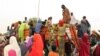 FILE - People, mostly women and children, internally displaced by Boko Haram militants, try to climb a truck protesting food shortages and a diversion of aid supplies meant for them, at a camp in Maiduguri, northeast Nigeria, on June 27, 2019.