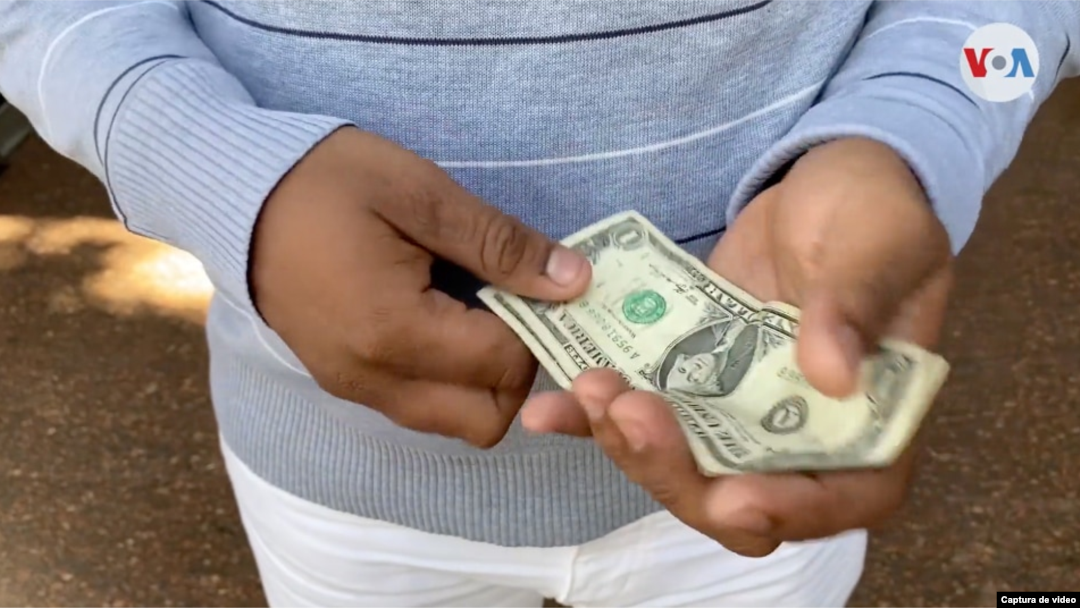 Un ciudadano cuentas billetes de dólares en Caracas, Venezuela. ]Foto: Captura de video]