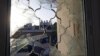 Israelis are seen through a window damaged after a rocket fired from the Gaza Strip landed in the southern town of Ofakim, November 18, 2012. 