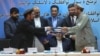 Afghanistan Peace Deal: Amin Karim, representative of Gulbuddin Hekmatyar, right, and Attaurahman Saleem, head of delegation of peace talks, left, exchange documents after signing a peace deal in Kabul, Afghanistan, Thursday, Sept. 22, 2016.