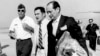 In this April 12, 1975, file photo, U.S. Ambassador to Cambodia John Gunther Dean carries the American flag from the U.S. Embassy in Cambodia as he arrives at Utapao Air Force Base in Thailand following the evacuation from Phnom Penh by helicopter and aircraft carrier.