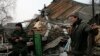 Geopolitical instability, as in eastern Ukraine, could undermine global economic growth, a new U.N. report warns. Here, a pro-Russian rebel and a resident view remnants of a house shelled near Donetsk, Ukraine, Dec. 14, 2014. 