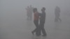 People wearing masks dance at a square amid heavy smog during a polluted day in Fuyang, Anhui province, China, Jan. 3, 2017. Fuyang is about 700 miles south of Beijing.