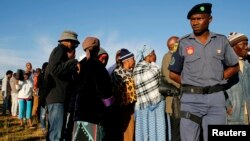 File - A police officer looks on at a voting station during the Lesotho national election in Magkhoakhoeng village outside the capital Maseru, Feb. 28, 2015. 