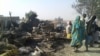 FILE - People return to the site after a bombing attack of an internally displaced persons camp in Rann, Nigeria Jan. 17, 2017.