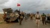 Shi'ite fighters are on the move in the town of Hamrin in Salahuddin province, March 3, 2015. Wearing military fatigues and a white turban, Shi'ite cleric Sheikh Ahmed al-Rubaei gave an eve-of-battle address to Iran-backed fighters preparing to attack IS.