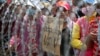 Cambodian garment workers shout slogans behind barbed wire set up by police near the Council of Ministers building during a rally in Phnom Penh, Cambodia, Monday, Dec. 30, 2013. The workers are demanding a raise in their monthly salary from US $160 to $80. (AP Photo/Heng Sinith)