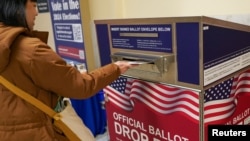 Seorang pemilih memasukkan surat suara dalam pemilihan pendahuluan di Balai Kota San Francisco, 4 Maret 2024 (Foto: Loren Elliott/Reuters)