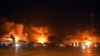 Api dan asap mengepul dari kontainer yang terbakar di lokasi serangan rudal, di pelabuhan kota pesisir Latakia, Suriah, Selasa pagi, 28 Desember 2021. (Foto: SANA via AP)