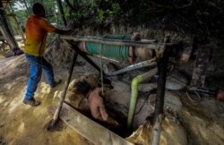 FILE - A miner descends into an underground gold mine in El Callao, Bolivar state, Venezuela, March 1, 2017.