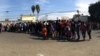 Miembros de la caravana, hacen fila para recibir comida, en Tijuana. Celia Mendoza - VOA 