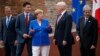 G7 leaders, from left, President of the European Commission Jean-Claude Junker, Canadian Prime Minister Justin Trudeau, German Chancellor Angela Merkel, President Donald Trump, and Italian Prime Minister Paolo Gentiloni, pose for a family photo at the Ancient Greek Theater of Taormina, May 26, 2017, in Taormina, Italy.