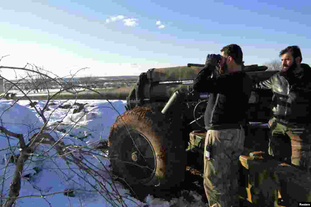 A Free Syrian Army fighter uses binoculars near the Menagh military airport, in Aleppo's countryside, Syria, January 10, 2013.