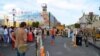 Tourists look on as protesters start pulling down their remaining Maidan tents, Independence Square, Kyiv, Ukraine, Aug. 11, 2014. (Jamie Dettmer/VOA)