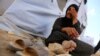 An Iraqi refugee woman from Mosul sits outside her family's tent at Khazir refugee camp outside Irbil, 217 miles (350 kilometers) north of Baghdad, Iraq, Friday, June 13, 2014.