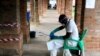 FILE - A health worker in protective gear prepares a disinfectant sprayer at a treatment center in Bikoro, Equateur province, Democratic Republic of Congo, May 13, 2018, during an earlier Ebola outbreak. 