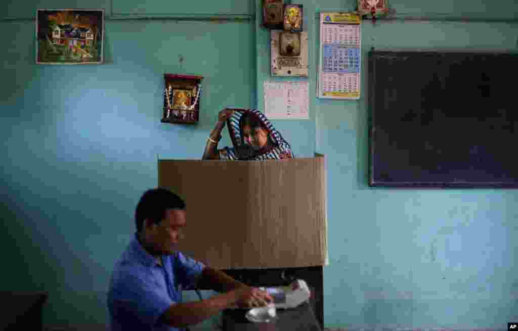 A woman adjusts her sari as she casts her vote during the first phase of elections in Dibrugarh, in the northeastern state of Assam, India, April 7, 2014.