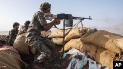 FILE - A Yemeni fighter backed by the Saudi-led coalition fires his weapon during clashes with Houthi rebels on the Kassara frontline near Marib, Yemen, June 20, 2021. 