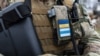 Шеврони бійця легіону "Свобода Росії": український прапор та неофіційний біло-синьо-білий прапор російських супротивників режиму Путіна. Фото: AFP/RFE/RL