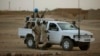 FILE - In this July 28, 2013 photo, United Nations peacekeepers stand guard at a polling station, during presidential elections in Kidal, Mali.