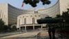 FILE - Paramilitary police officers stand guard in front of the headquarters of the People's Bank of China, the central bank (PBOC), in Beijing, Sept. 30, 2022. 