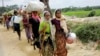 FILE - Rohingya refugees, who crossed the border from Myanmar two days earlier, walk after they received permission from the Bangladesh army to continue their way to Kutupalong refugee camp, near Cox's Bazar, Bangladesh, Oct. 19, 2017.
