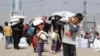 People who fled the Islamic State's strongholds of Hawija and Mosul receive aid at a camp for displaced people in Daquq, Iraq, Oct. 13, 2016.