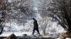 An Afghan man walks in the season's first snow in Paghman district of Kabul, Afghanistan, Jan. 4, 2017. Despite the usual harsh winters, Afghanistan security forces plan to continue their operations against the Taliban and Islamic State. 