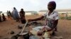 FILE - An unidentified woman who fled her home following an attack by Islamist militants, in Mubi, prepares a meal at the camp for internally displaced people in Yola, Nigeria.