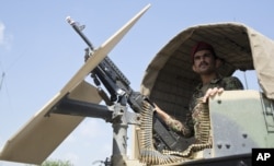 FILE - An Afghanistan National Army soldier stands guard in his vehicle in Camp Khogyani in Nangarhar province, east of Kabul, Afghanistan.