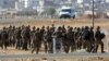 Turkish soldiers take their position a few hundreds meters from the the Turkey-Syria border in Mursitpinar, near Suruc, as fighting intensified between Syrian Kurds and the militants of Islamic State, Oct. 5, 2014.