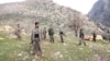 PKK fighters stand guard during the release of eight Turkish prisoners in the northern Iraqi city of Dohuk, March 13, 2013. (Reuters)